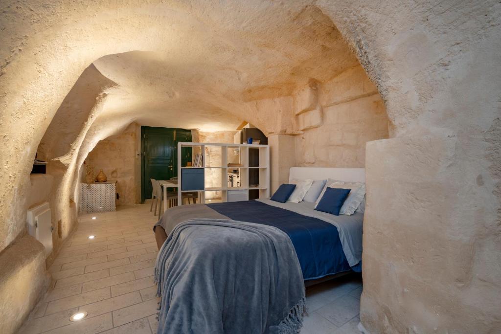 Un dormitorio con una cama en una habitación de piedra. en La grotta di Lulù, en Matera