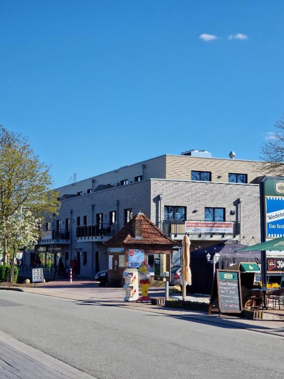a building on a street with a market in front of it at Penthouse-Ferienwohnung "Tom" in Butjadingen