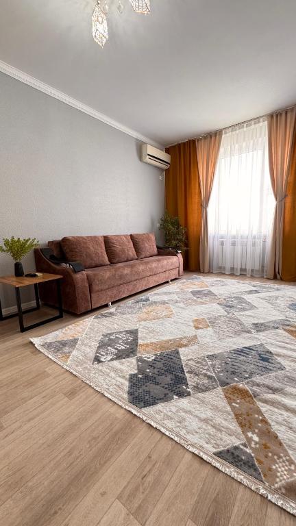 a living room with a couch and a rug at Квартира 6-35 in Aktau