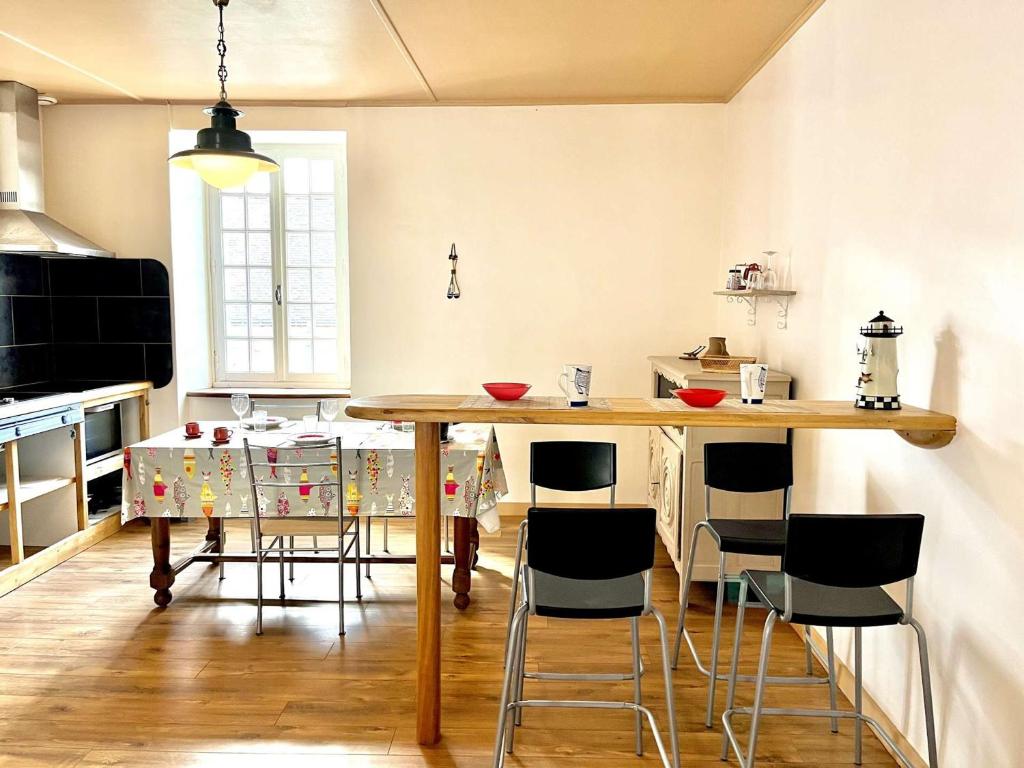 une cuisine avec une table et des chaises en bois dans l'établissement Spacieux studio 48 m², cœur de ville, Étretat - FR-1-479-221, à Étel
