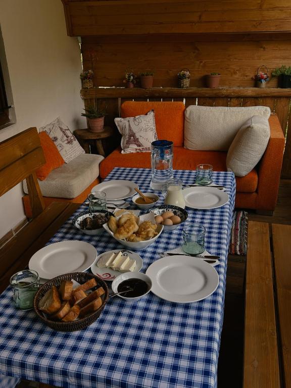 a table with plates of food on a blue and white checked table cloth at Guesthouse Lola in Valbonë