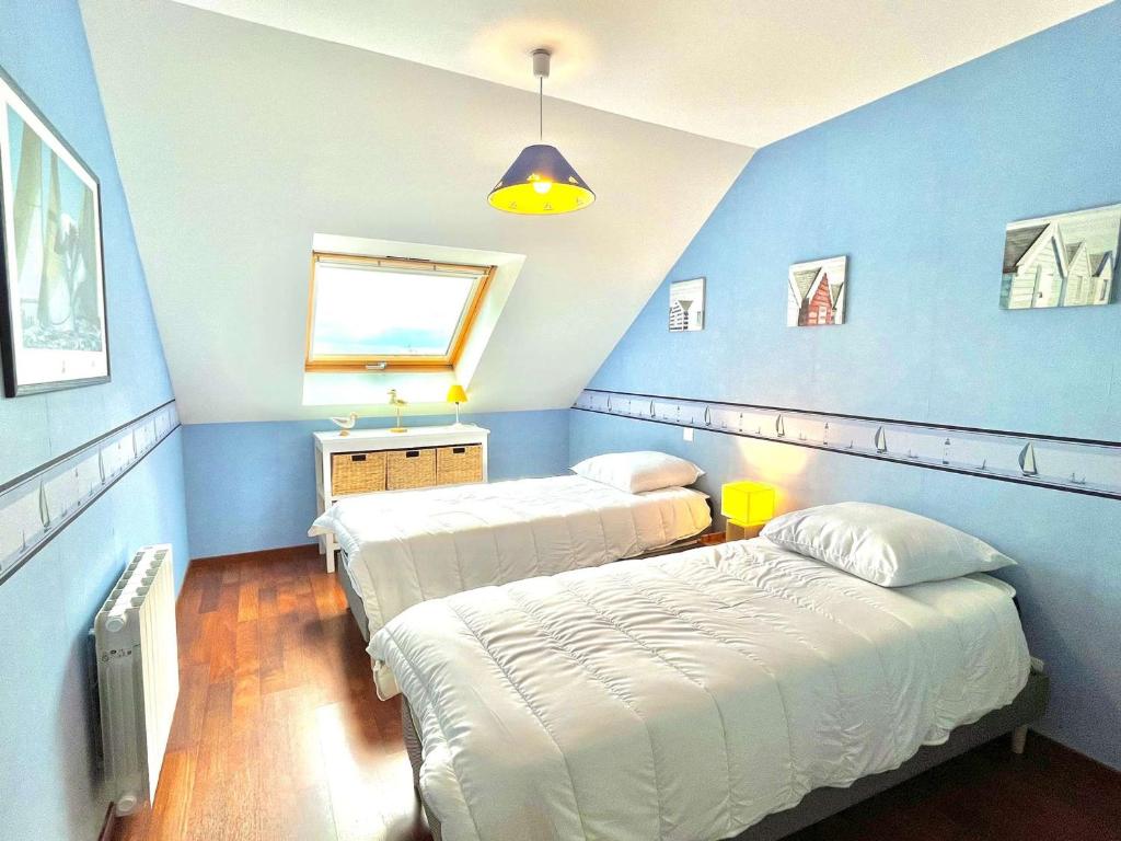two beds in a room with blue walls at Étel - Appart. 3 pièces, terrasse, animaux admis, parking sécurisé - FR-1-479-226 in Étel