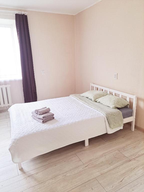 a bedroom with a white bed with towels on it at Baznicas Str Apartments in Liepāja