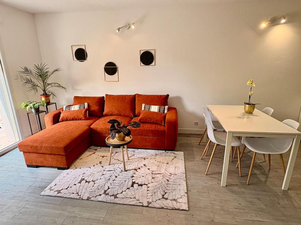 un salon avec un canapé et une table dans l'établissement Appartement cosy, terrasse privée, parking, centre ville, à Mont-de-Marsan