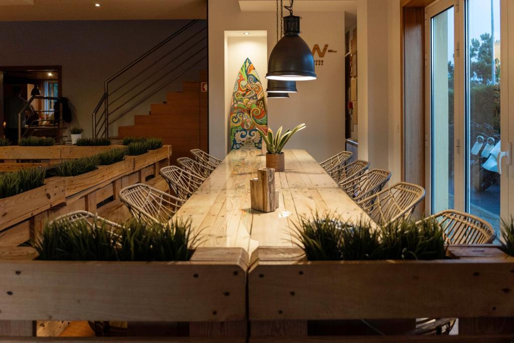 a dining room table with chairs and a christmas tree at Golden Waves Surf and Yoga Lodge Furadouro in Ovar