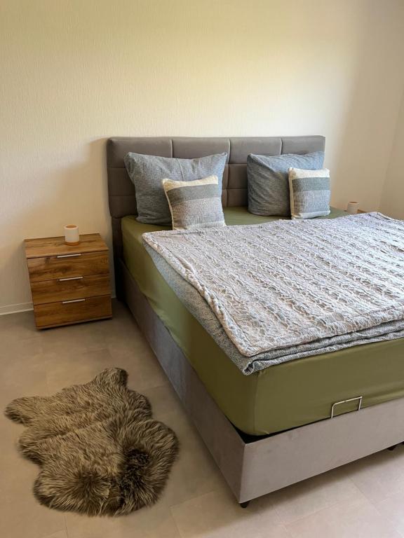 a bedroom with a bed with a pile of pillows at Ferienwohnung Burkart in Ebersburg