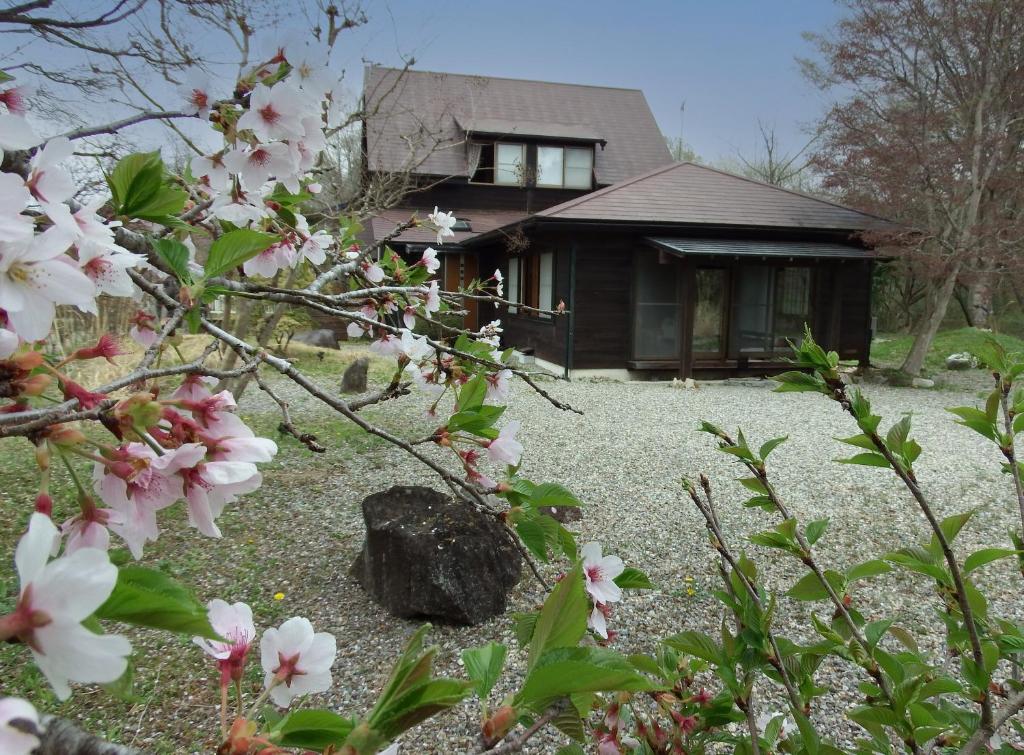 a house with pink flowers in front of it at pet friendly Nasu Royal Villa リニューアルOpen ペットと泊まれる貸切別荘 那須ロイヤルヴィラ in Nasu