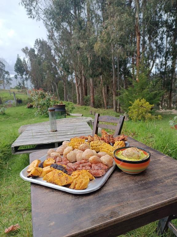 un tavolo da picnic con un vassoio di cibo sopra di Eco-cabaña piemonte a Guasca