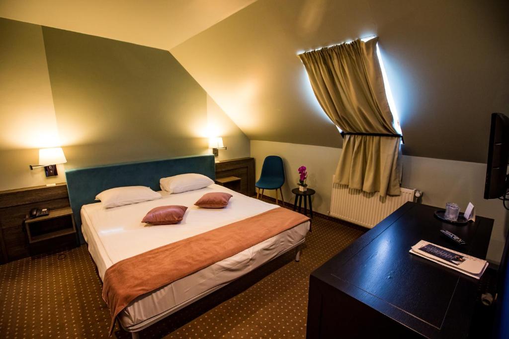 a hotel room with a bed and a window at Hotel Arena in Târgu-Mureş