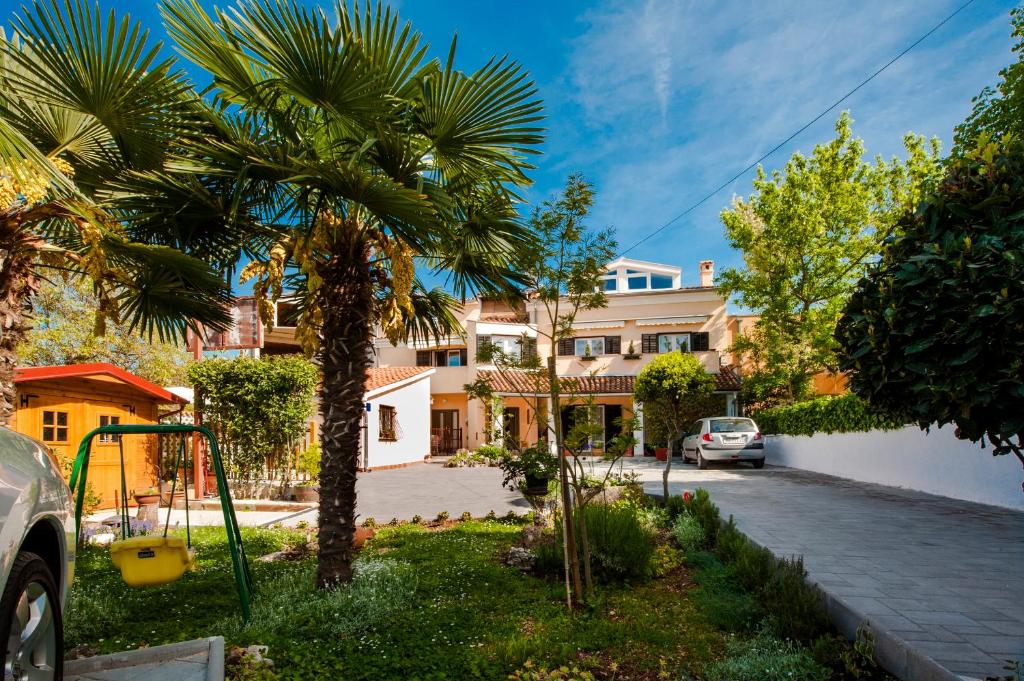 a palm tree in the yard of a house at Apartments Rina in Rovinj