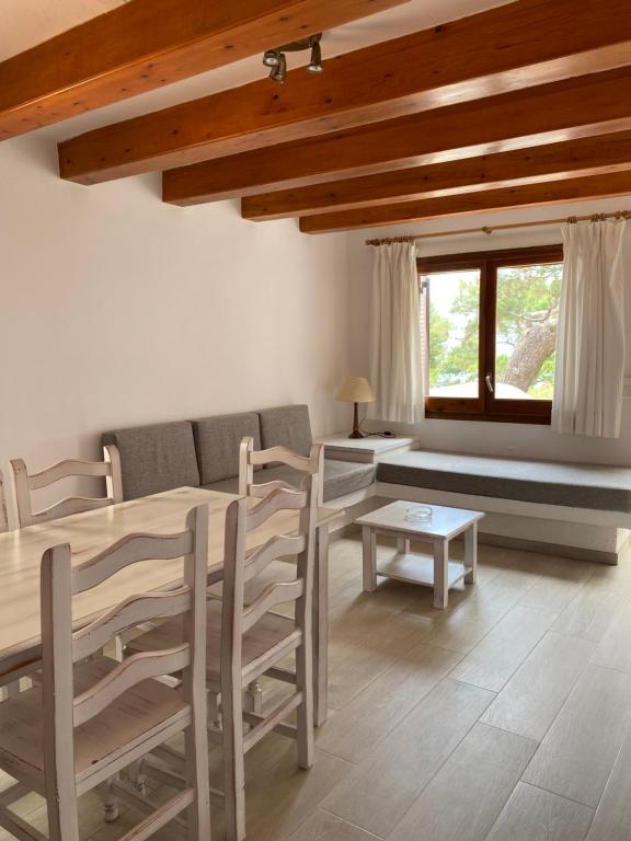 a living room with a table and chairs and a couch at Apartamentos LLorca in Platja de l’Almadrava