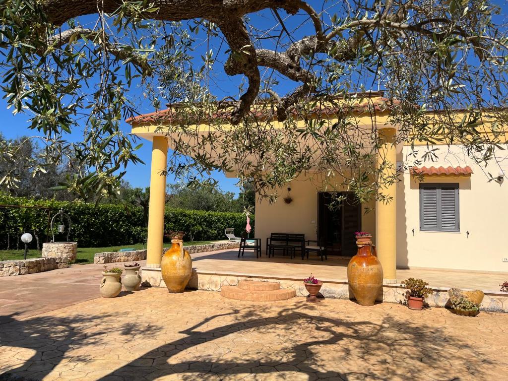 eine Gruppe Vasen, die vor einem Haus sitzen in der Unterkunft Villa Pergola in San Michele Salentino