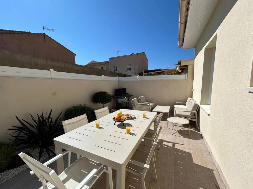 - une table et des chaises blanches sur le toit-terrasse dans l'établissement Desbo, à Valras-Plage