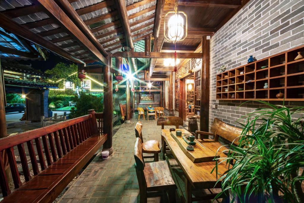 a restaurant with tables and chairs and a brick wall at Yangshuo Scenic Mountain Retreat in Yangshuo