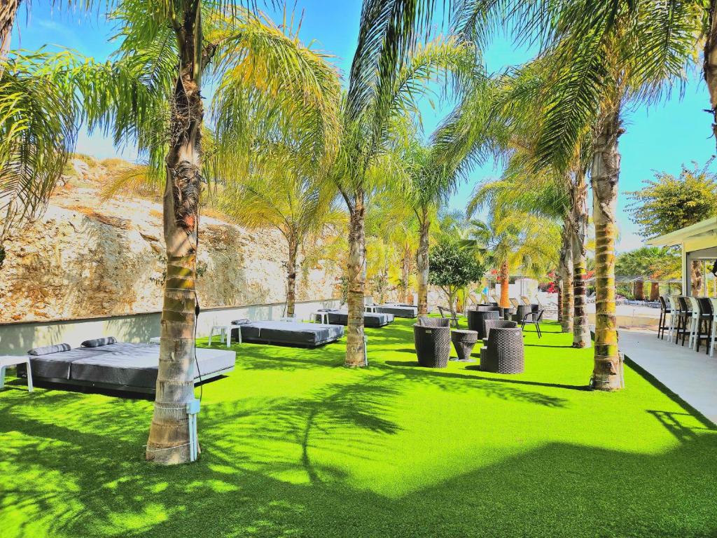 a park with palm trees and green grass at Corfu Hotel in Ayia Napa