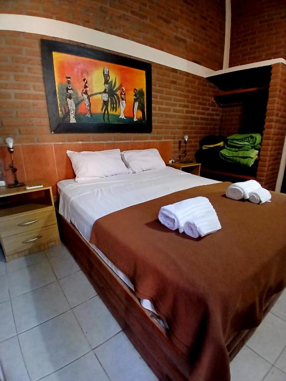 a bedroom with a large bed with towels on it at Cabañas Costa Santino in Ituzaingó