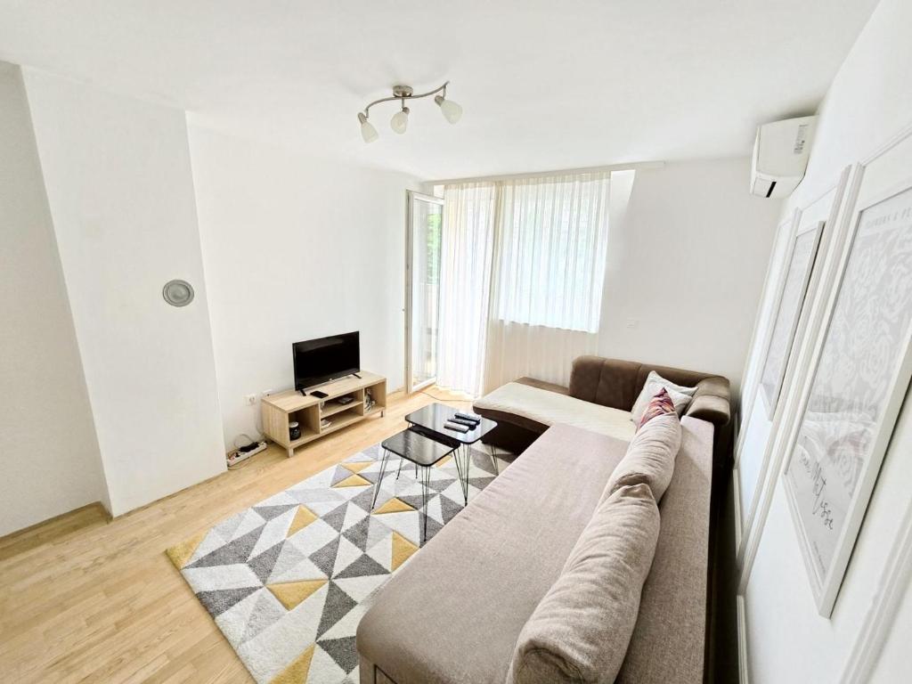 a living room with a couch and a tv at Departure Apartment in Sarajevo