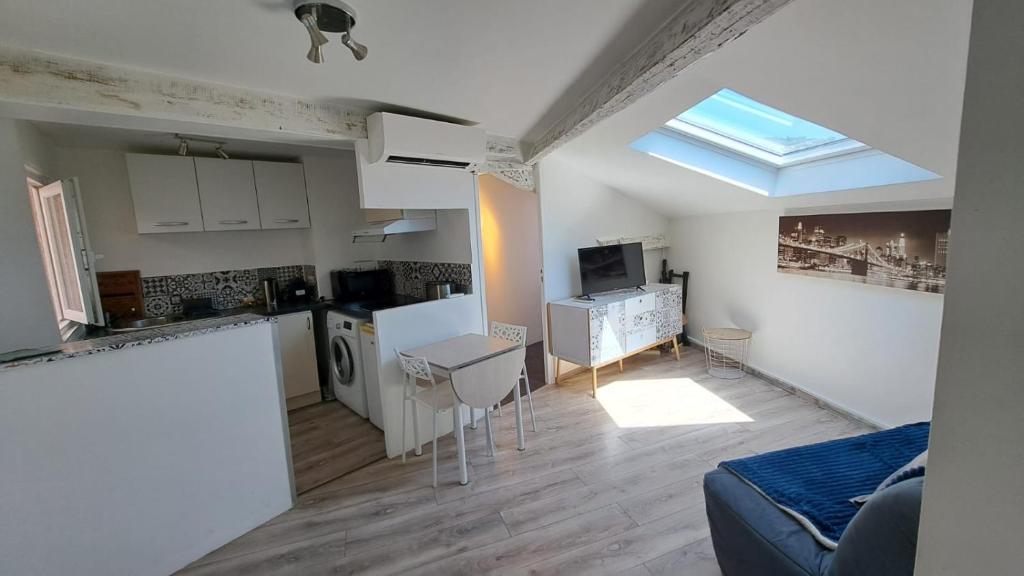 Il comprend une cuisine et un salon avec une fenêtre. dans l'établissement Joli 2 pièces rénové à proximité du centre et plage, à Cannes