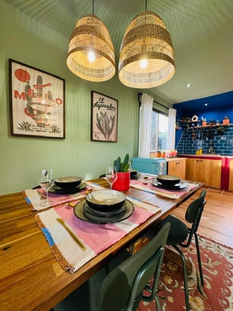 a dining room with a table with chairs and chandeliers at Mexican House in Cortesia
