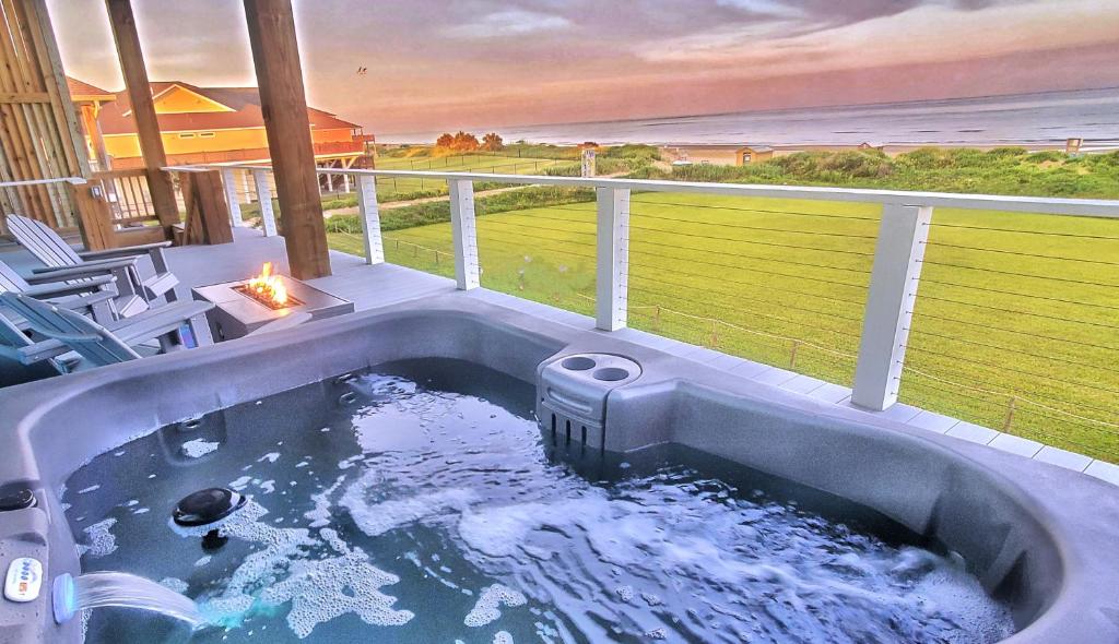 a hot tub on a balcony with a view of the ocean at Beachfront - Hot Tub - Home Theater in Bolivar Peninsula