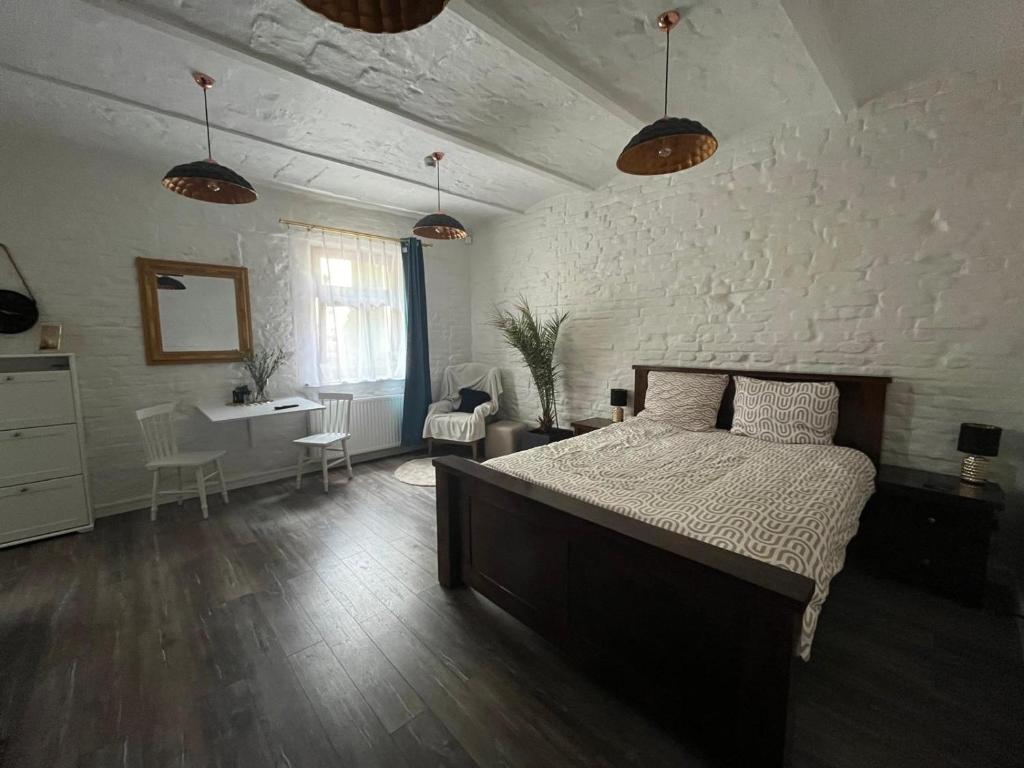 ein Schlafzimmer mit einem großen Bett und einer weißen Wand in der Unterkunft Zacisze Krasińskiego in Toruń