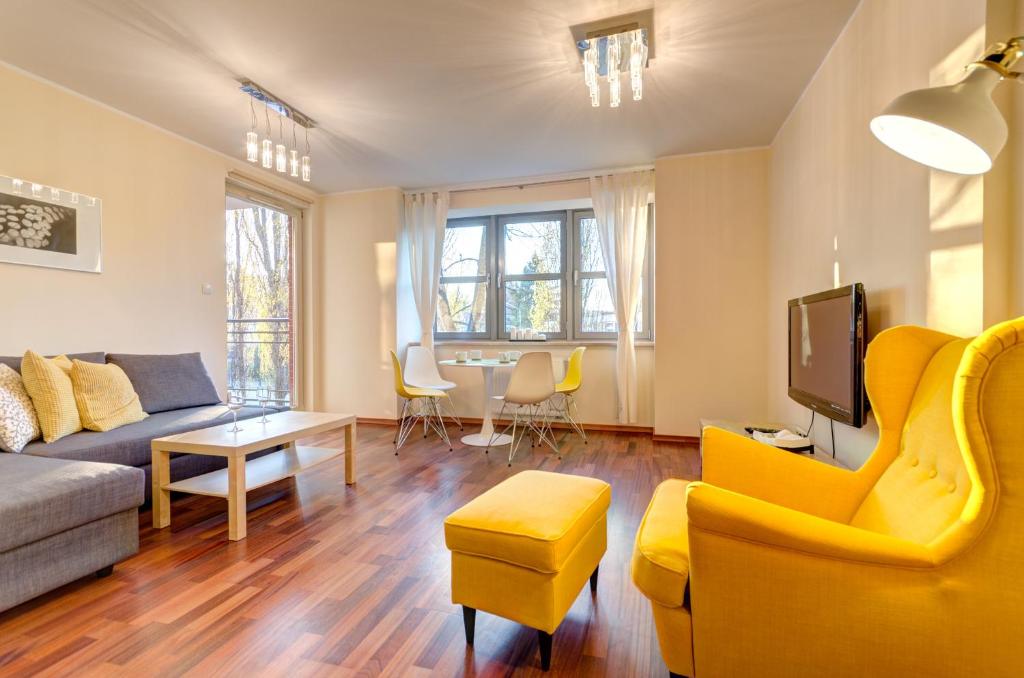 ein Wohnzimmer mit einem Sofa und einem TV in der Unterkunft Dom & House - Apartamenty Kamienice Nad Motławą in Danzig