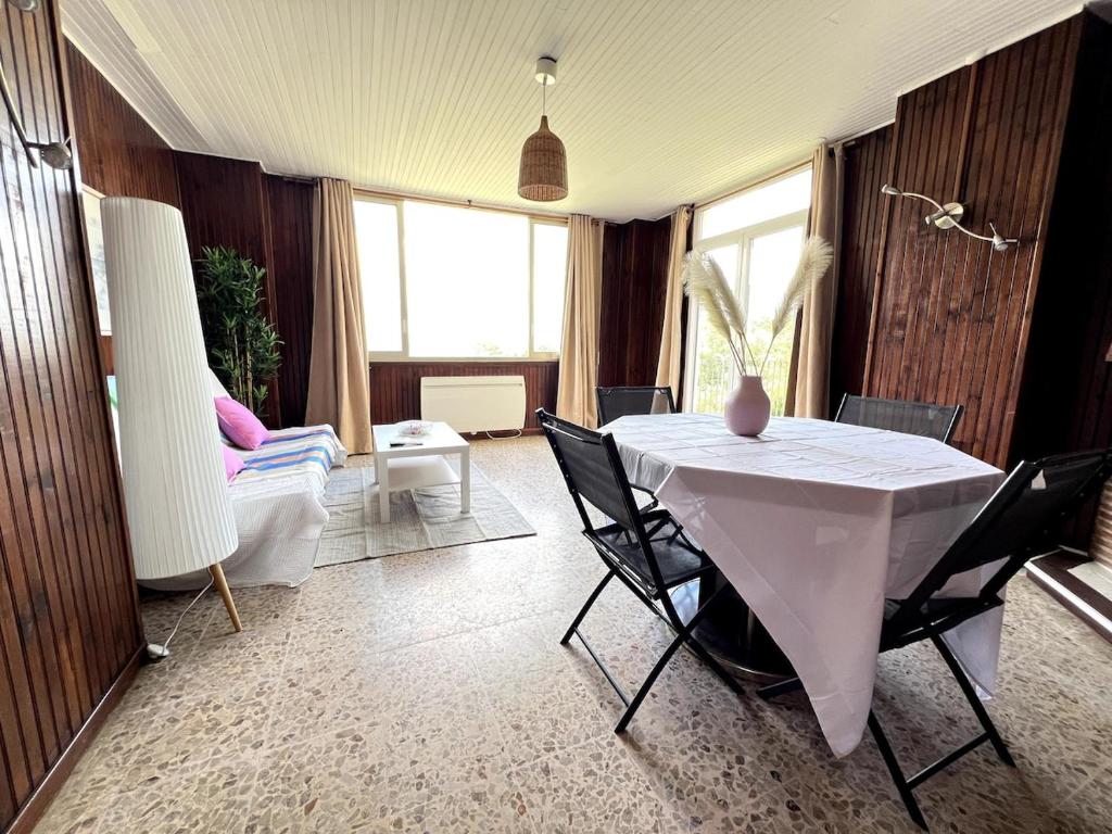 un salon avec une table et des chaises blanches dans l'établissement Between Land and Sea, à Hyères