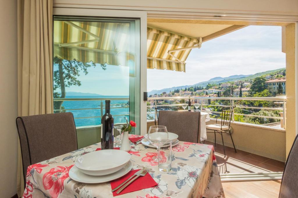 a dining room with a table and a view of the ocean at Apartments Villa Dinka in Opatija
