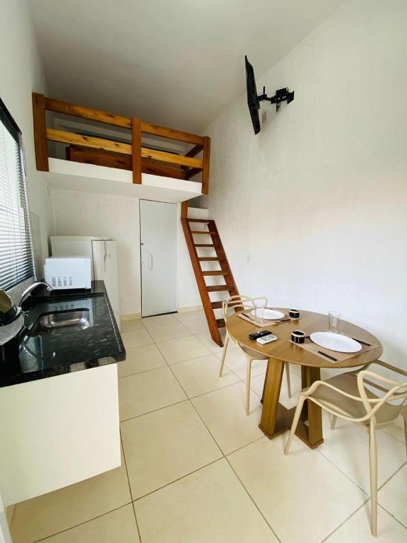 a room with a table and a kitchen with a ladder at Pousada do sol in Sorocaba