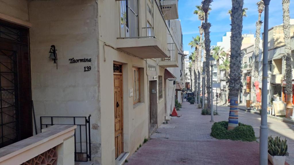 a city street with a building with a sign on it at 139 Taormina Apartment in St Paul's Bay