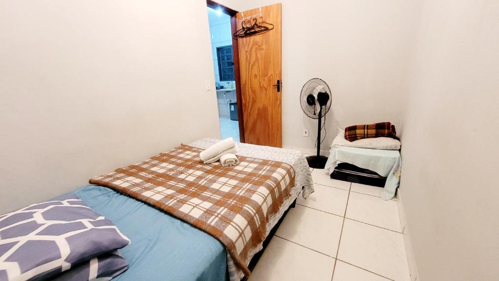 a small bedroom with a bed and a fan at sss in Campinas