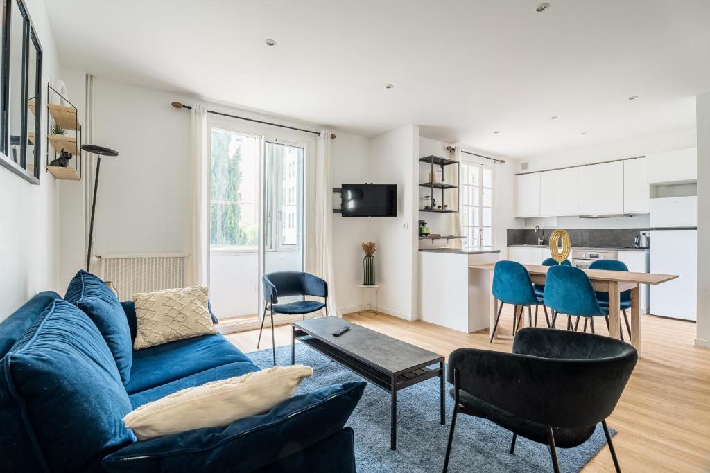 un salon avec un canapé bleu et une table dans l'établissement Superbe Appartement Moderne, Prado,à Deux Pas du Vélodrome, à Marseille