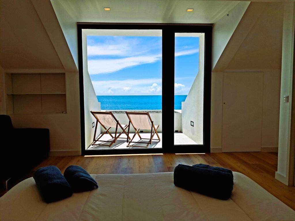 a bedroom with a bed and a view of the ocean at Casa Dona Isabel - ocean suites in Lagoa