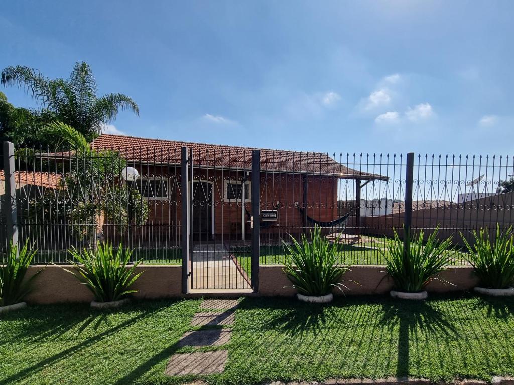 a fence in front of a house with plants at Casa - Águas de São Pedro in Águas de São Pedro