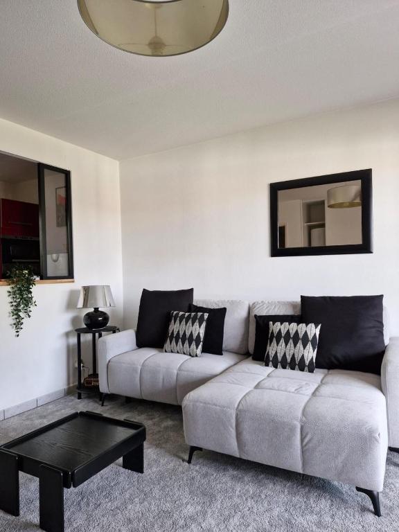 un salon avec un canapé et une table dans l'établissement Joli T2 sur golf Bassussary, à Bassussarry