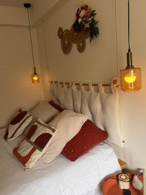 a bed with white sheets and pillows in a room at L'écrin de la villa des roses in Pontmain