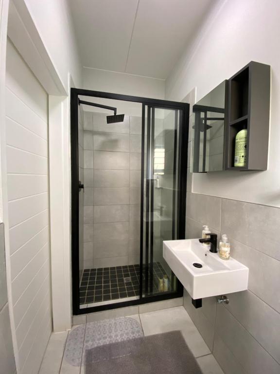 a bathroom with a shower and a white sink at Elegant escape in Krugersdorp