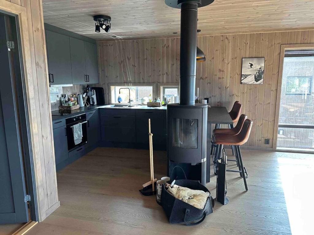 a kitchen with a stove in the middle of a room at Cabin at Norefjell! Perfect for families with children in Runn
