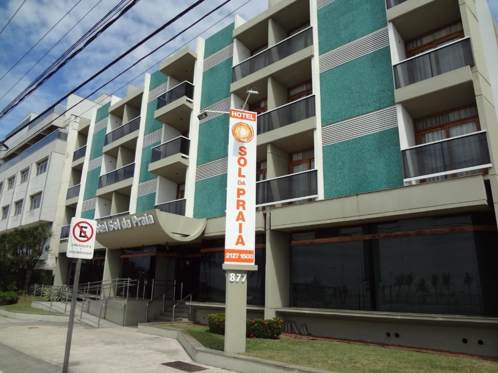 un bâtiment avec un panneau d'hôtel devant lui dans l'établissement Hotel Sol da Praia, à Vitória