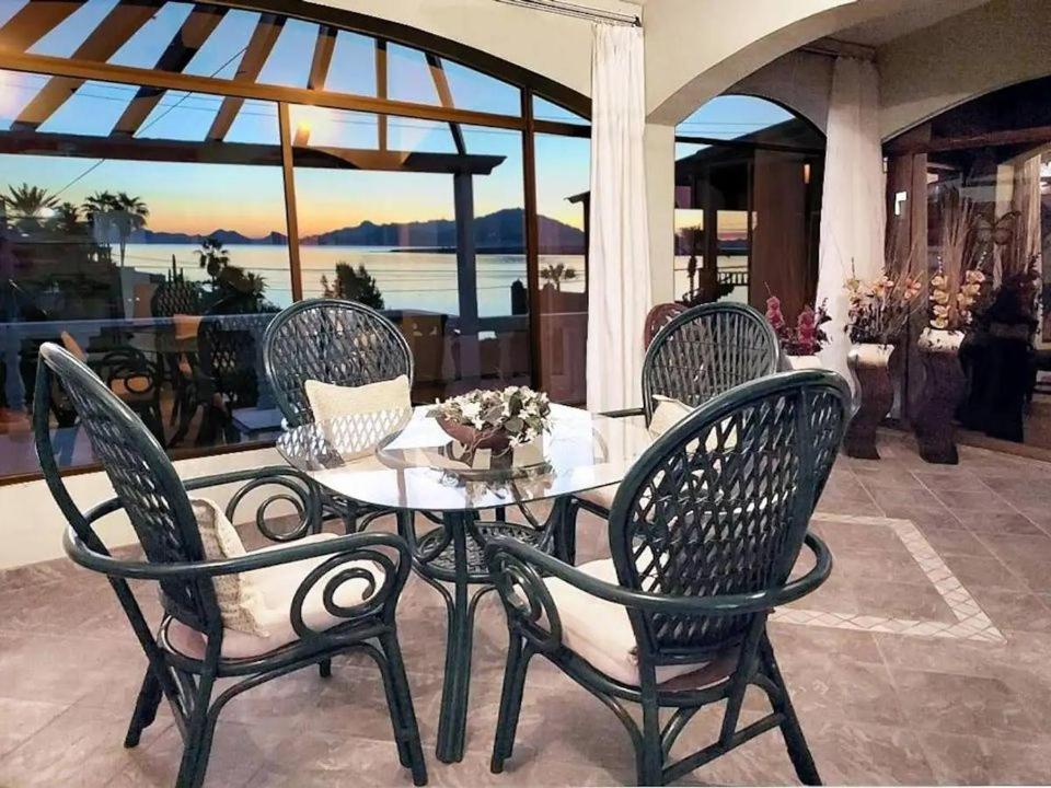 een tafel en stoelen op een patio met uitzicht op de oceaan bij Villa Hermosa Ocean View 2 Bed in San Carlos