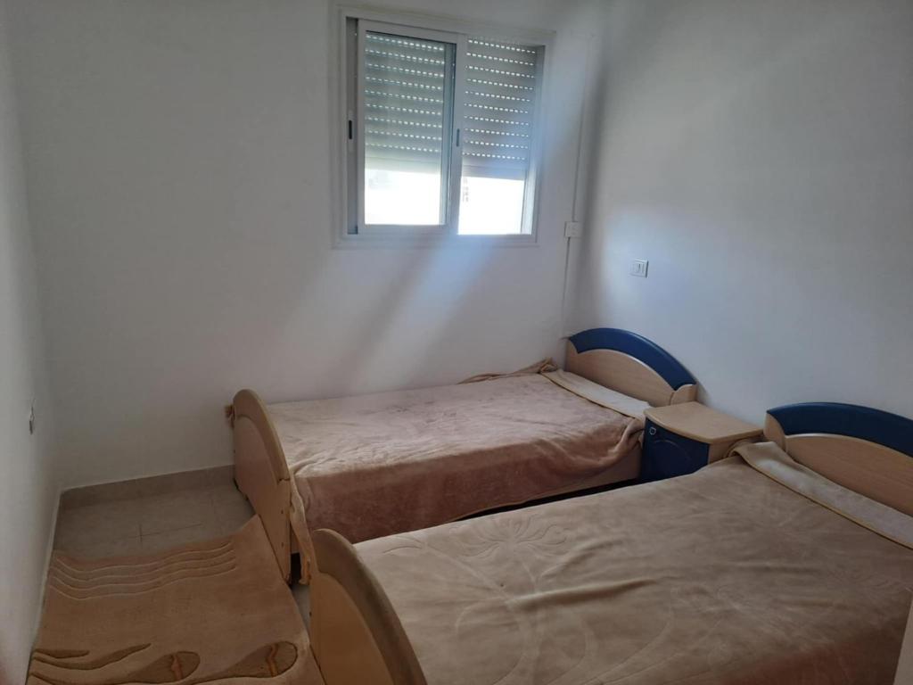 Postel nebo postele na pokoji v ubytování Apparemment Kelibia