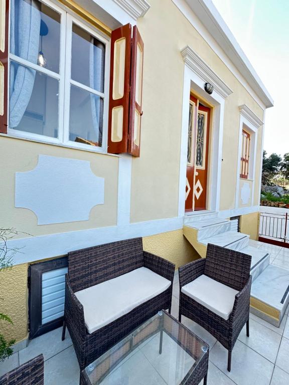 a patio with two chairs and a table at Seaside escape in Symi