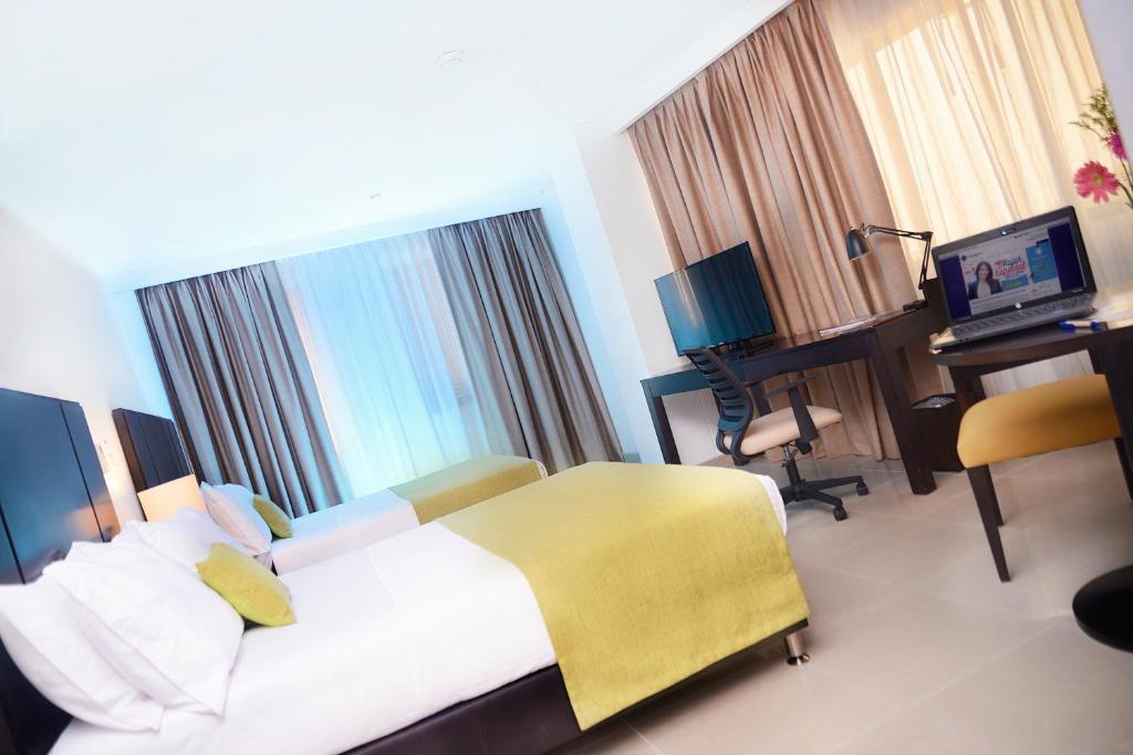 Postel nebo postele na pokoji v ubytování Hotel Millenium Barrancabermeja
