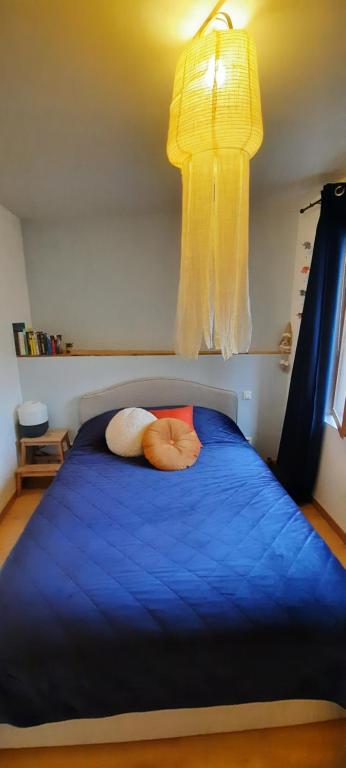 une chambre avec un lit bleu avec deux oreillers dessus dans l'établissement Maison de village Bédoin, à Bédoin