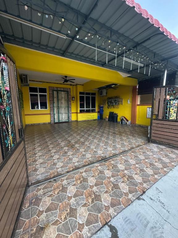a room with a stone floor and yellow walls at Homestay Bukit Katil Damai 2 in Ayer Keroh