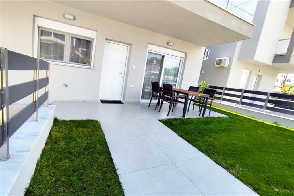 a patio with a table and chairs in a house at Stasia Apartment in Nikiti