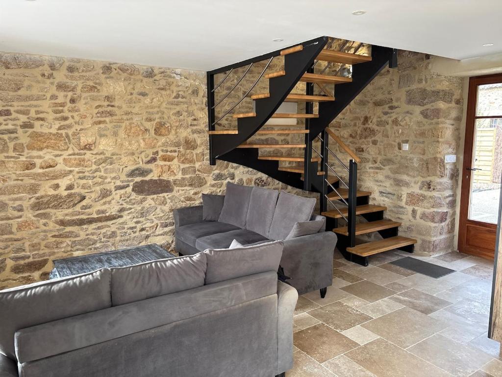 a living room with a couch and a staircase at 2 gîtes à la campagne, proche mer, 18 personnes in Landévant