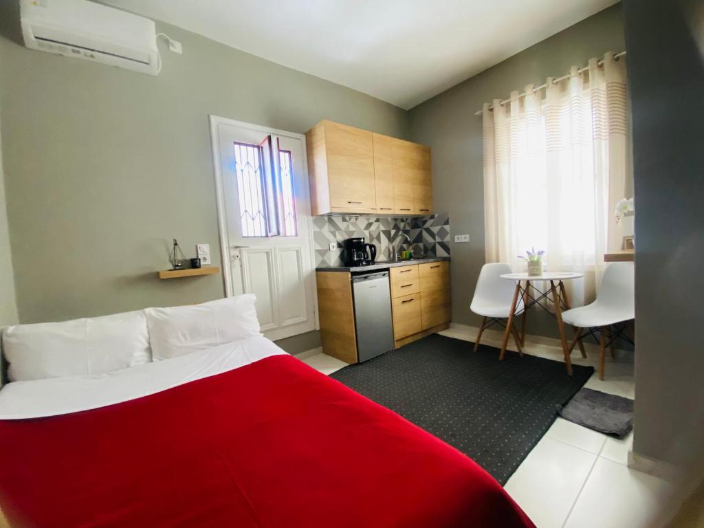 a bedroom with a red bed and a kitchen at The Central Retreat 4 in Mytilini