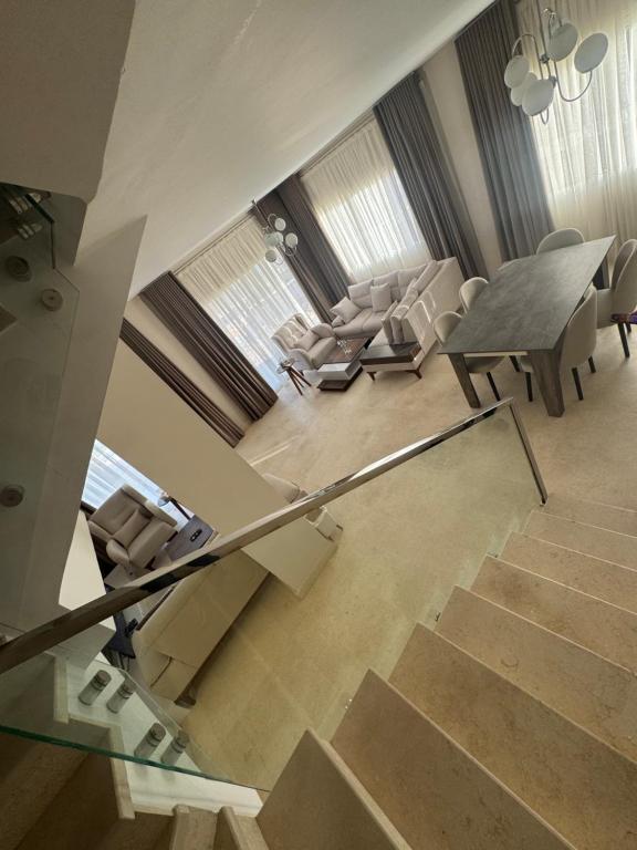 a living room with stairs and a table and chairs at Villa Mountain View 4 October in ‘Ezbet `Abd el-Ḥamîd