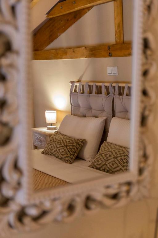a reflection of a bed with pillows in a mirror at Strofilia House Near ATH Airport in Markopoulo